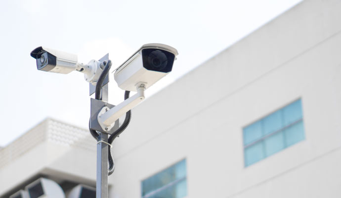 Pole-mounted commercial CCTV cameras covering a parking lot at a South Florida business